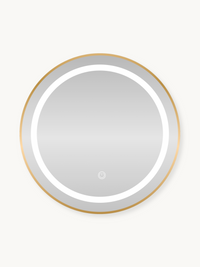 Round LED bathroom mirror with gold metal frame, illuminated white ring light, and touch power button, front view on cream…