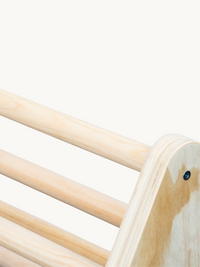 Close-up of natural wood ladder rungs and rounded plywood side panel on a children's climbing frame, screw detail visible