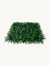 Rectangular artificial green ivy wall panel viewed at a slight angle, showing dense layered small leaves with wispy edges…