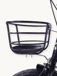 Close-up of black wire front basket with moulded plastic base, mounted above the front wheel and brake of the Borneo 12-in…