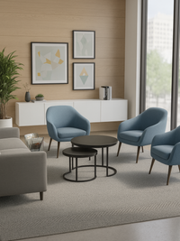 Two black round nesting side tables with steel ring bases styled in a modern office lounge beside blue armchairs and a lar…