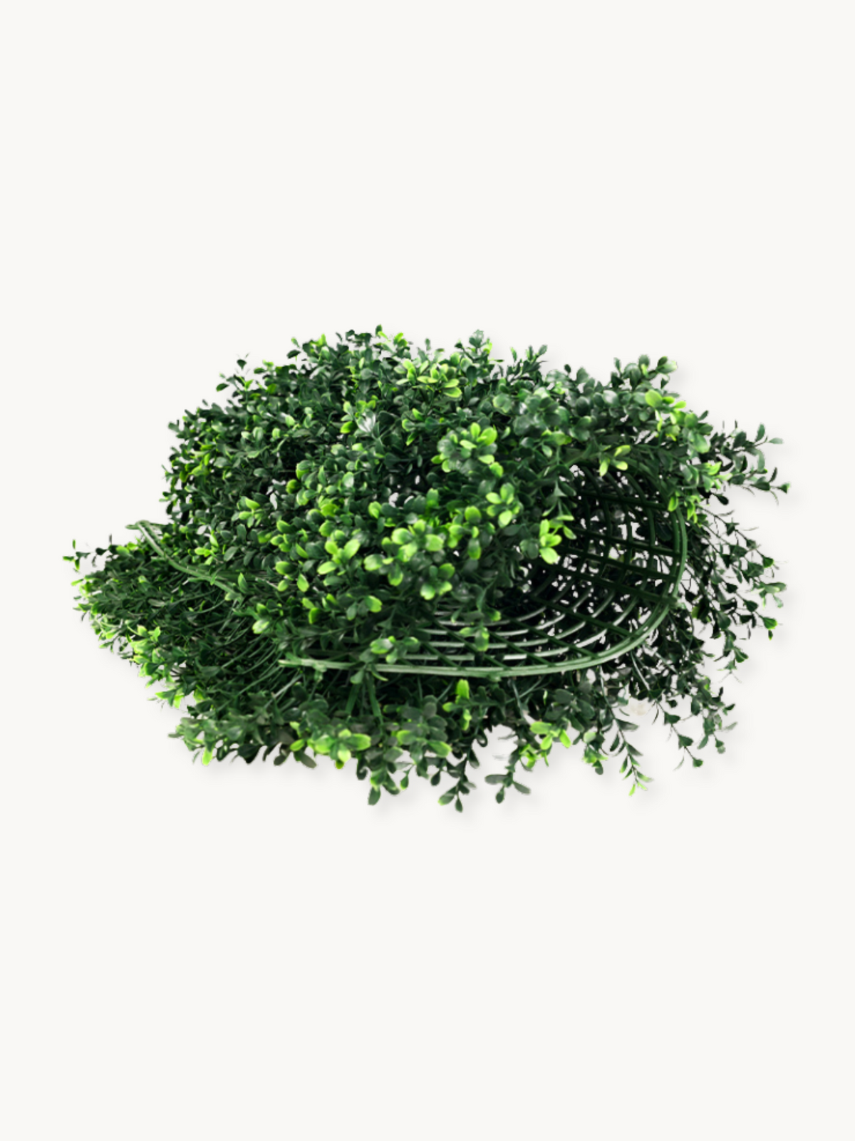 Artificial green ivy wall panel laid flat, top-down angle, showing dense small leaves spilling over a dark wire frame backing