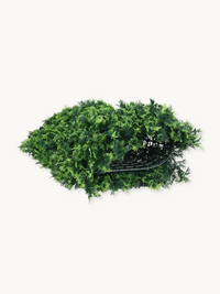 Underside of an artificial green hedge panel showing black plastic grid frame, with dense olive green foliage overhanging…