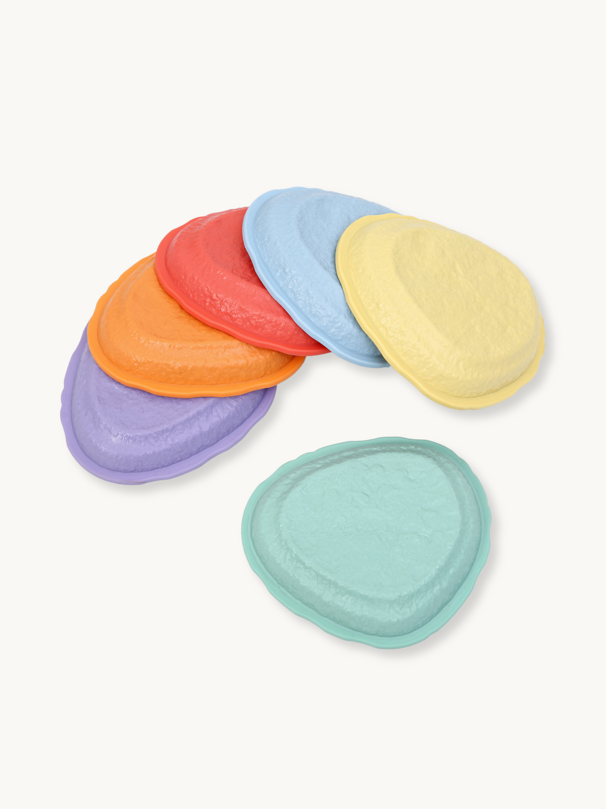 Six pastel plastic balance stepping stones in purple, orange, red, blue, yellow, and mint, fanned out on white background