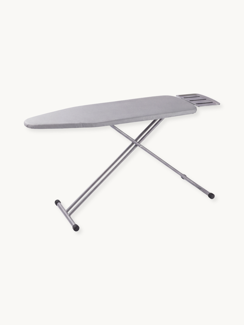 Light grey ironing board with silver steel X-frame legs, slotted iron rest at narrow end, rubber feet, angled product view