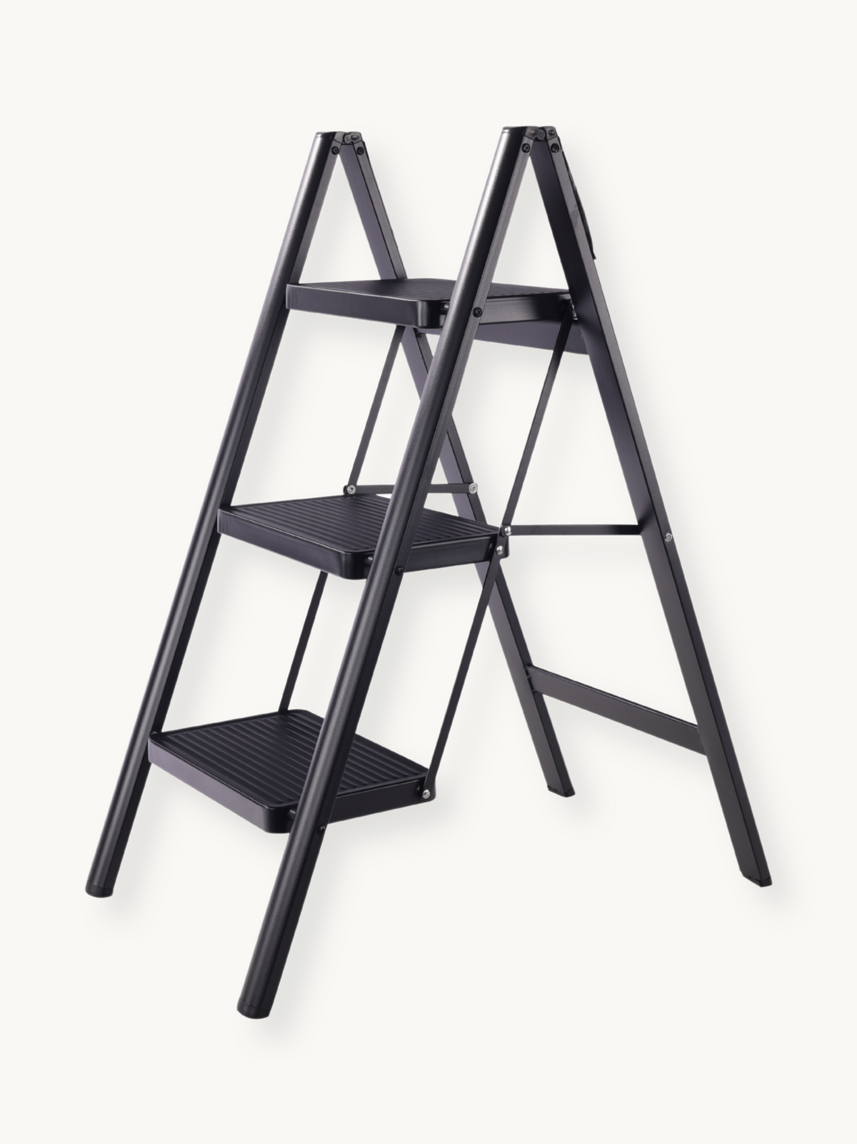 Black 3-step folding ladder angled front view showing ribbed step surfaces, A-frame metal frame, and hinge joints against…