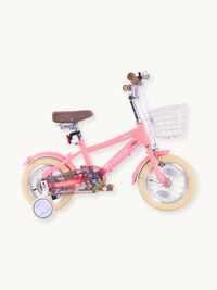 Pink Luna 12-inch girls' bike, full side view, with training wheels, front wire basket, brown saddle, and cream rubber tyres