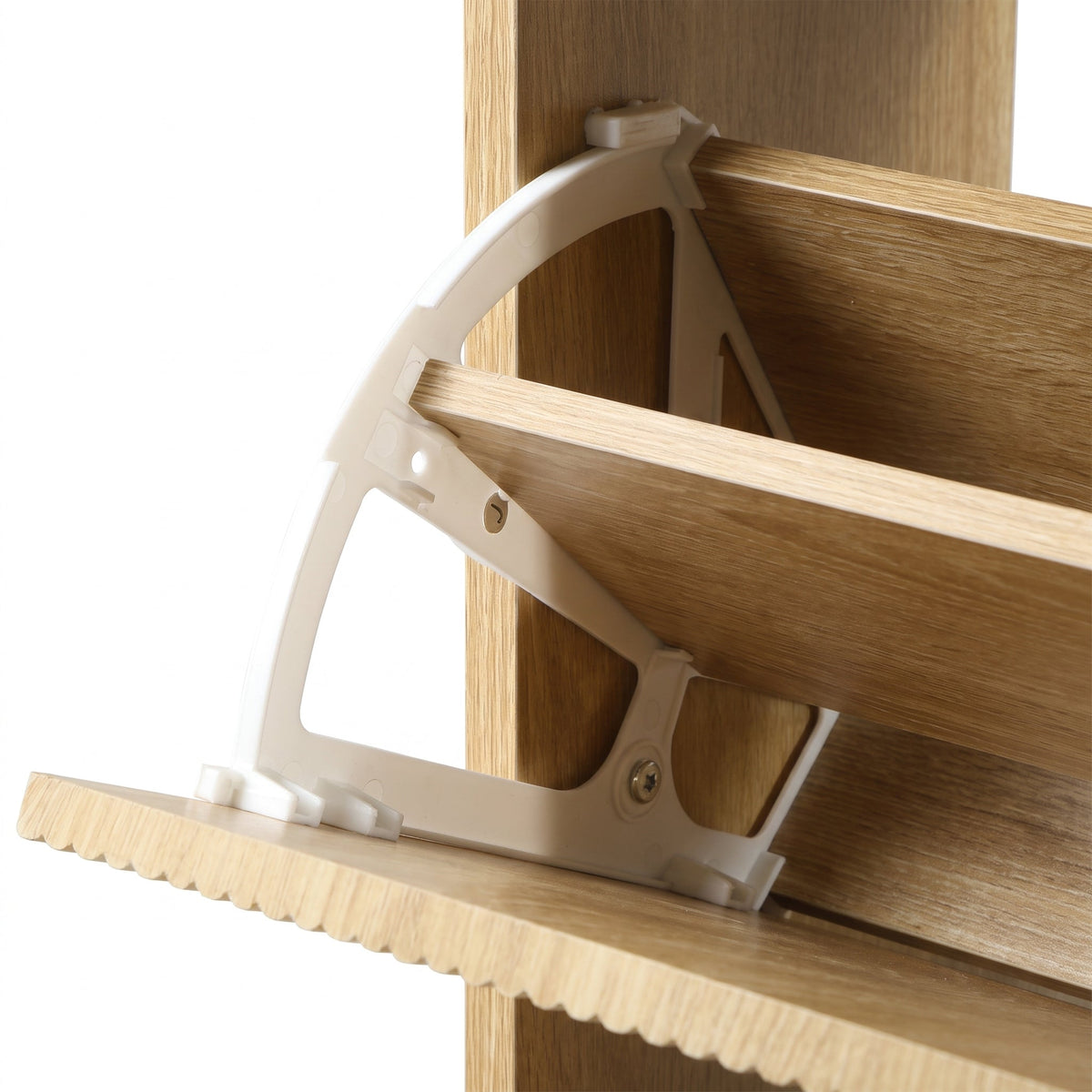 Close-up of white plastic semicircular hinge bracket securing a flip door to the oak-finish shoe cabinet's wooden frame