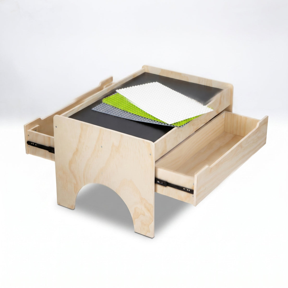 Natural wood play table angled from below, both side drawers open, showing grey chalkboard surface with green, white and g…