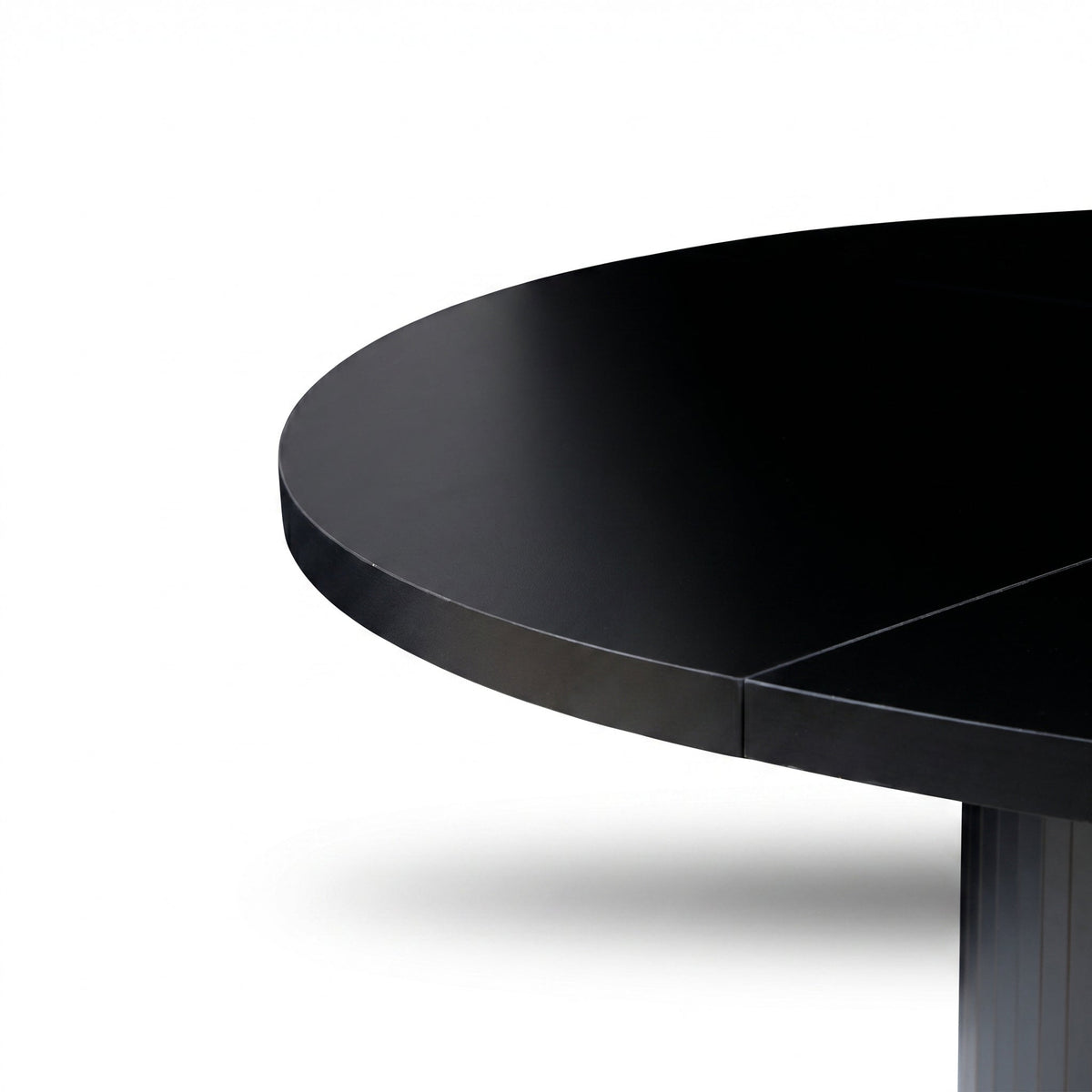 Close-up of black matte round tabletop edge and upper ribbed pedestal base, showing panel join seam detail, white background