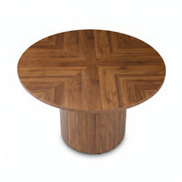 Overhead angle showing herringbone walnut veneer pattern radiating from centre of round tabletop, ribbed drum pedestal bas…