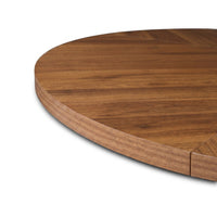 Close-up of rounded edge and warm walnut herringbone tabletop surface, showing wood grain detail and segmented join at rim