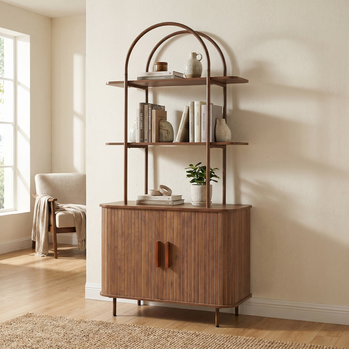 Walnut bookcase with arched metal top frame styled with books and ceramics, ribbed cabinet base, lifestyle room setting