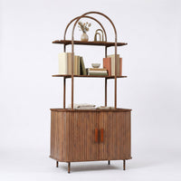 Angled front view of walnut bookcase showing arched metal frame, ribbed sliding doors with brown handles, and open shelves…
