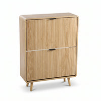 Light oak shoe cabinet with two flip-down doors, black bar handles, rounded edges, and angled splayed legs, front three-qu…