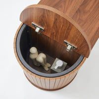 Top-down view inside open flip-top compartment of walnut oval shoe bench, black inner lining, silver hinges visible, small…