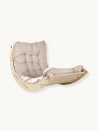 Pale wood mini rocking arch with fitted beige tufted cushion, angled three-quarter view on white background