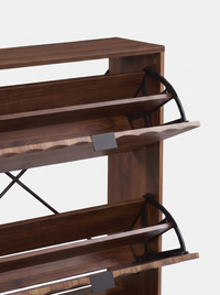 Close-up of walnut-finish shoe cabinet showing two flip-down compartments open, revealing black metal pivot hinges and tra…