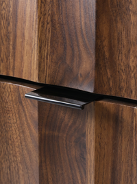 Close-up of dark glossy black recessed handle on walnut-finish cabinet door, showing rich wood grain detail