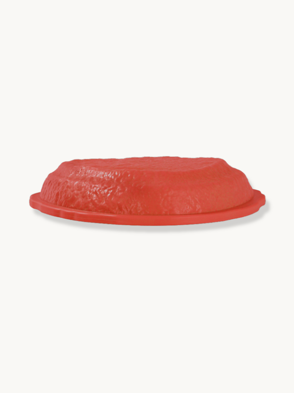 Red plastic balance stone, side angle showing textured top surface and flat rimmed base, on white background