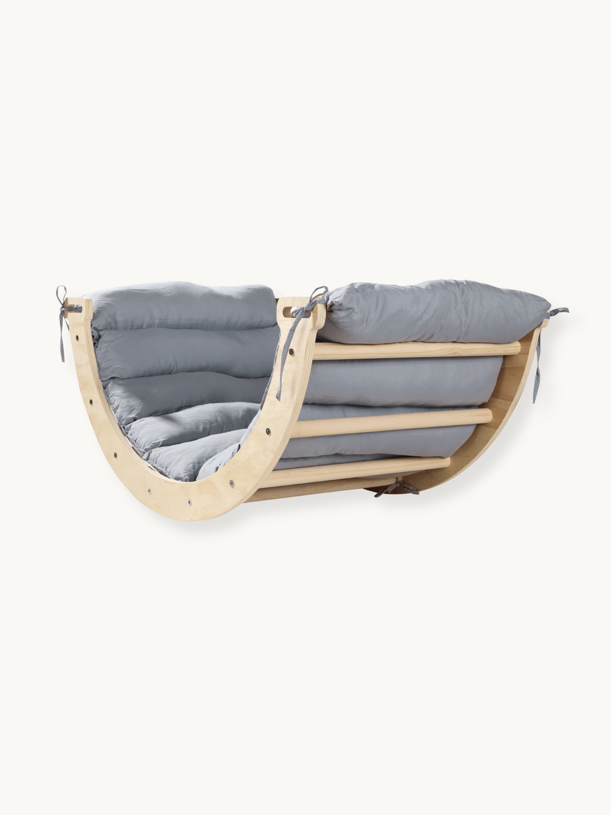 Natural wood mini climbing arch rocker with grey quilted cushion tied on, angled view showing curved sides and slatted bas…