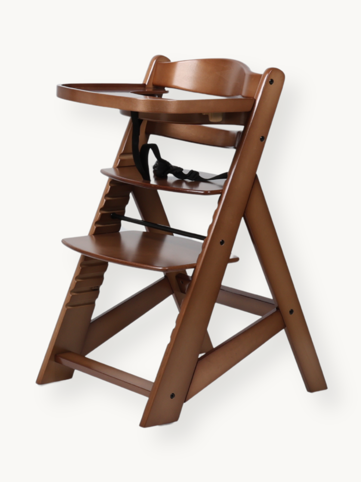 Walnut solid wood high chair angled side view showing adjustable seat, footrest height positions, black harness, and attac…