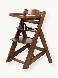 Walnut solid wood high chair angled side view showing adjustable seat, footrest height positions, black harness, and attac…