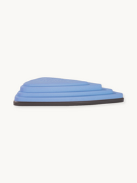 Periwinkle blue triangular balance stone, side profile showing stepped concentric layers and dark grey rubber base edge