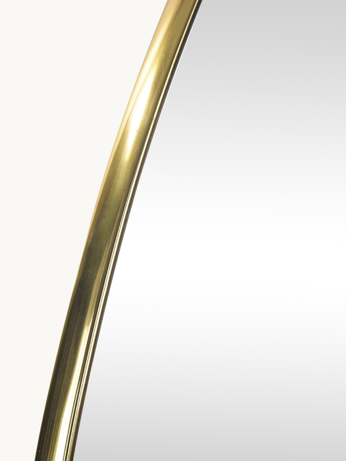 Close-up of brushed gold PVC frame curving along the upper edge of the Rafael organic wall mirror, showing frame texture a…