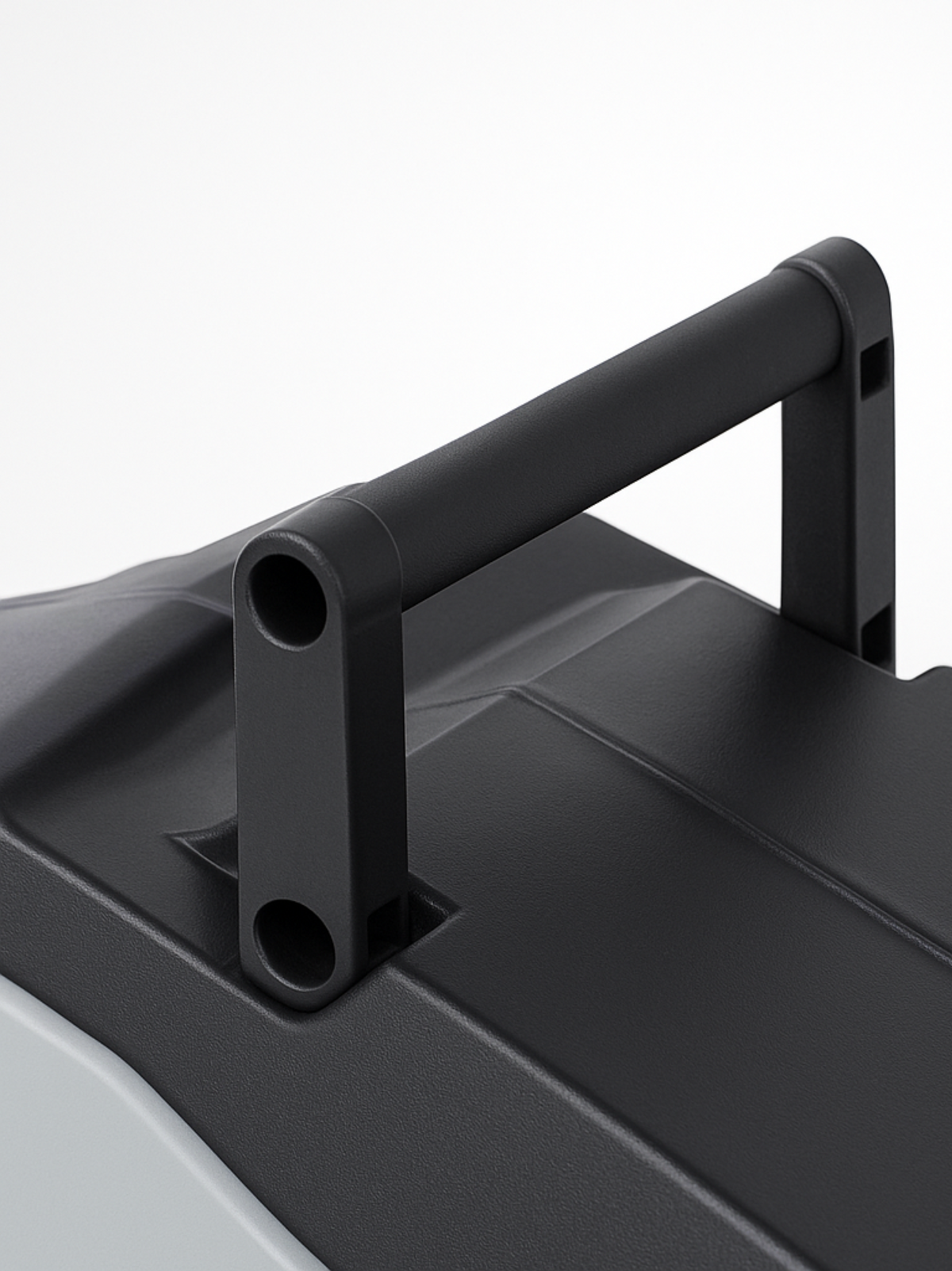 Close-up of black matte carry handle on top of hose reel casing, showing tubular grip and bracket mounting detail