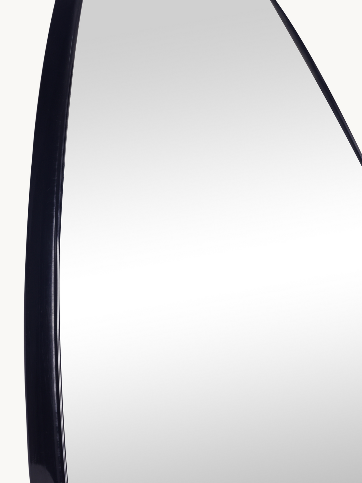 Close-up of Alaric mirror's curved black PVC frame edge, showing frame depth and glass surface detail against off-white ba…