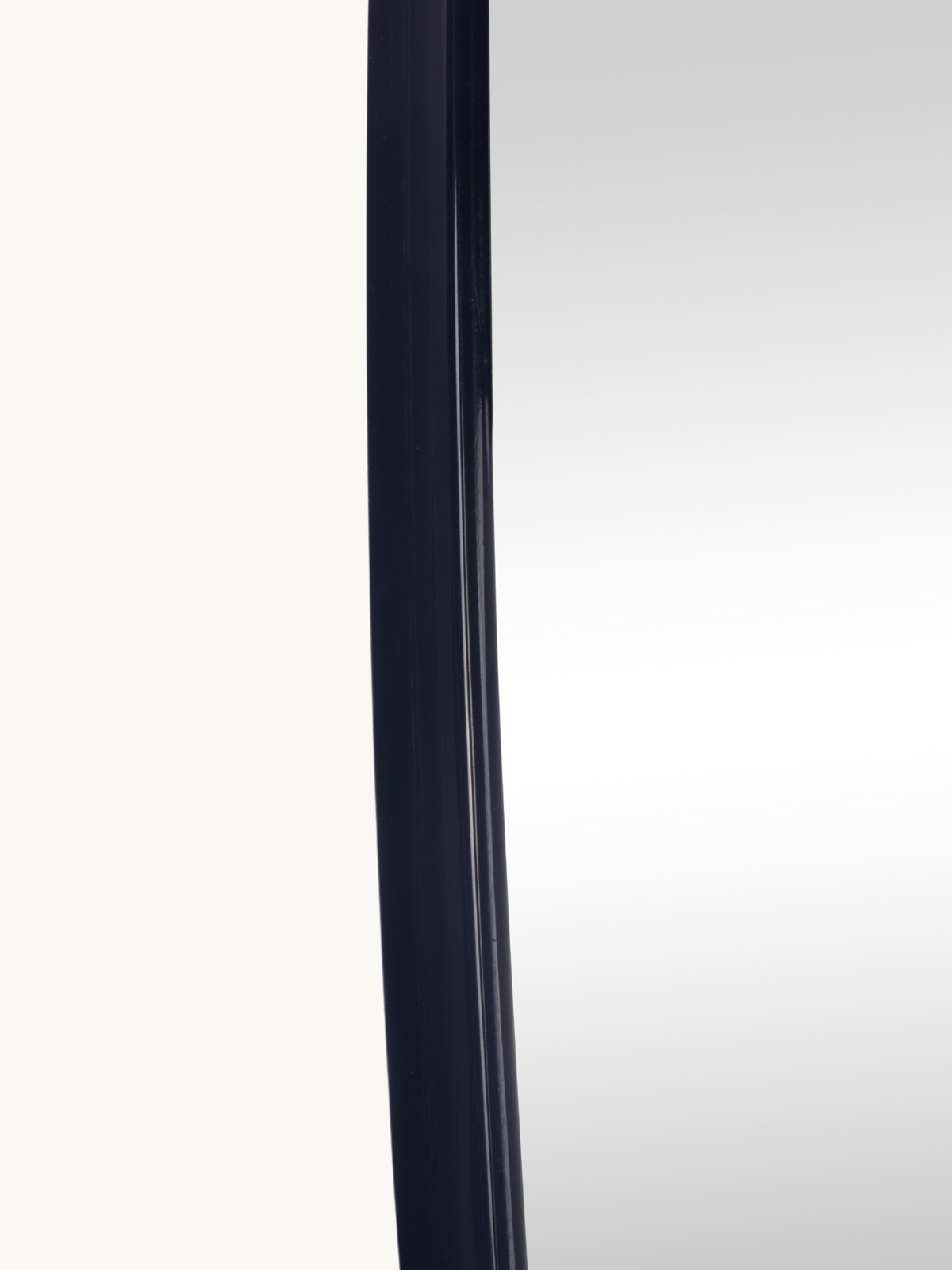 Close-up of the left edge showing the thin black PVC frame profile and mirror surface detail