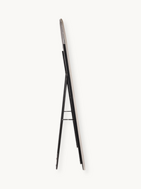 Side profile view of white suede velvet oval standing mirror showing slim frame edge and black metal A-frame support legs