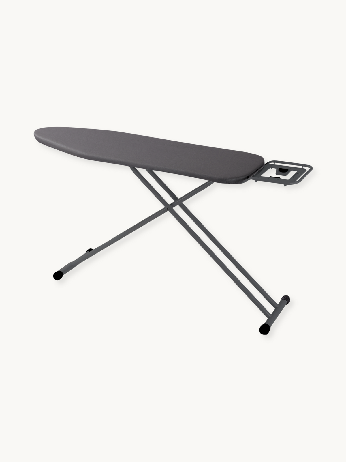 Dark grey ironing board at low angle, showing padded cotton cover, iron rest bracket, cross-frame steel legs, and rubber f…