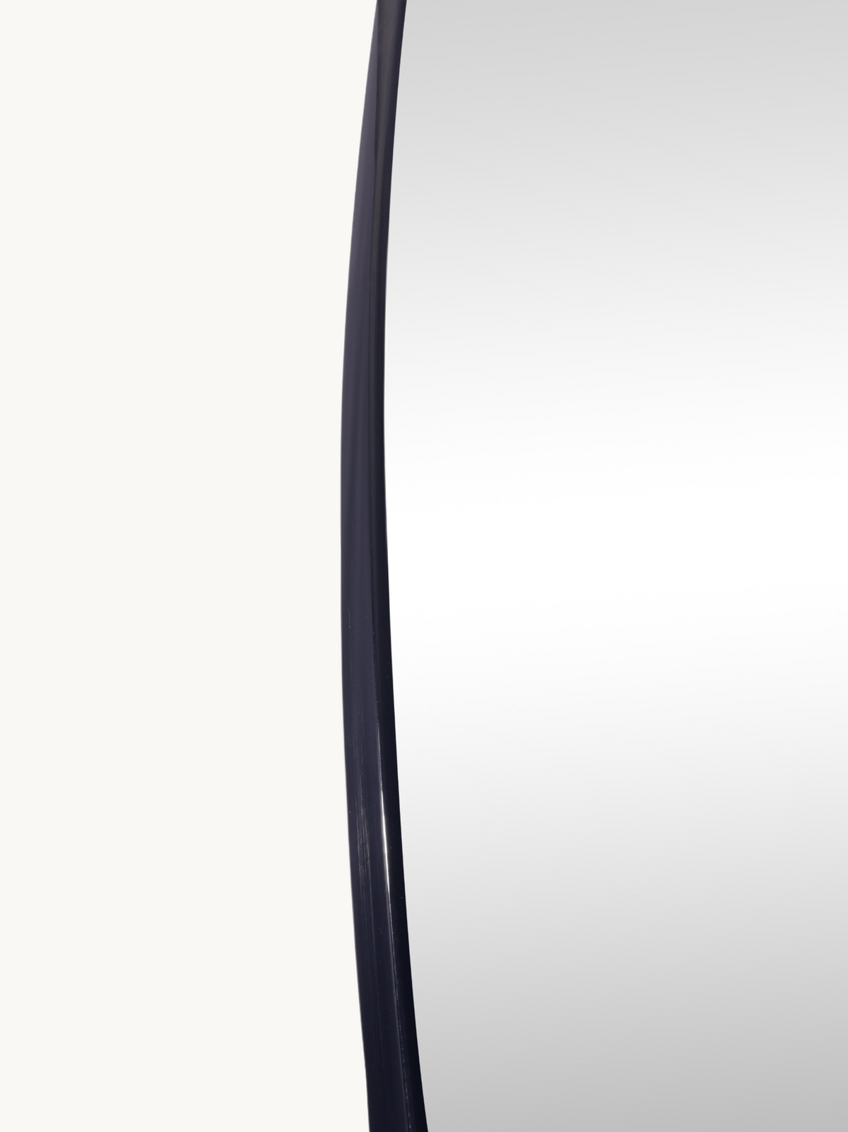 Close-up of Rafael mirror's curved left edge showing slim black PVC frame profile against white background