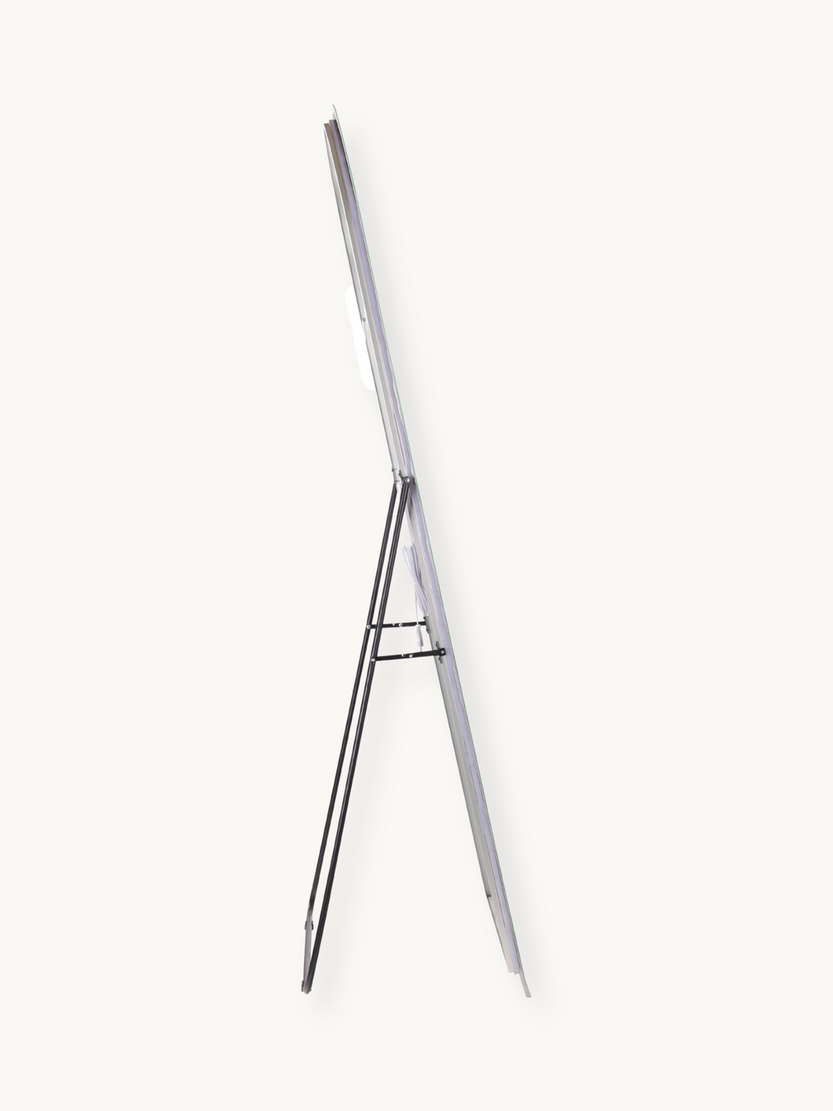 Narrow side profile of frameless full-length mirror on black metal easel stand, showing slim edge depth and support legs