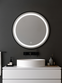 Round LED bathroom mirror with black frame mounted above white vessel sink on dark grey bathroom wall, LED ring lit, lifes…