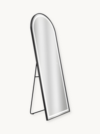 Black arched full-length LED mirror on open easel stand, angled three-quarter view showing black aluminium frame and white…