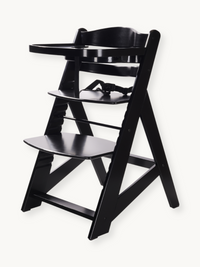 Black wooden adjustable highchair angled view, no cushion fitted, showing safety harness, removable tray, and stepped foot…