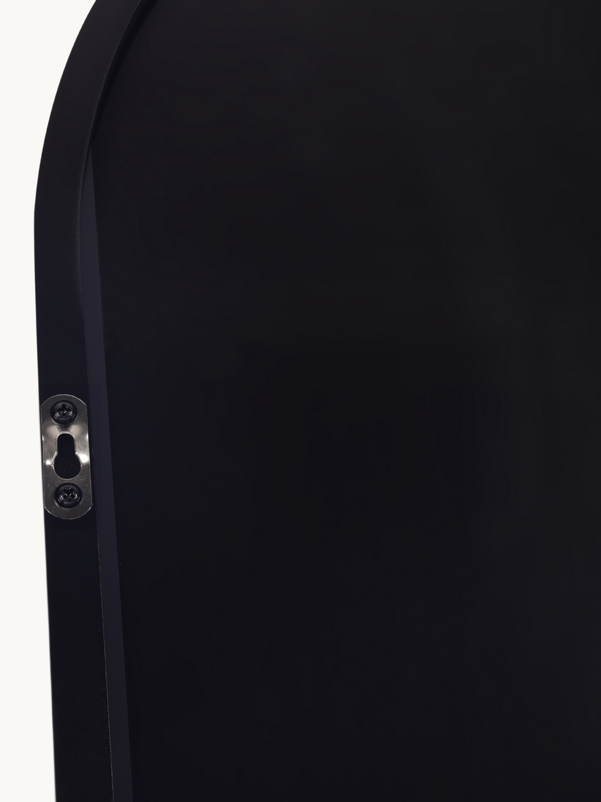 Close-up of black aluminium oval mirror frame edge showing silver keyhole wall-mount bracket with screws