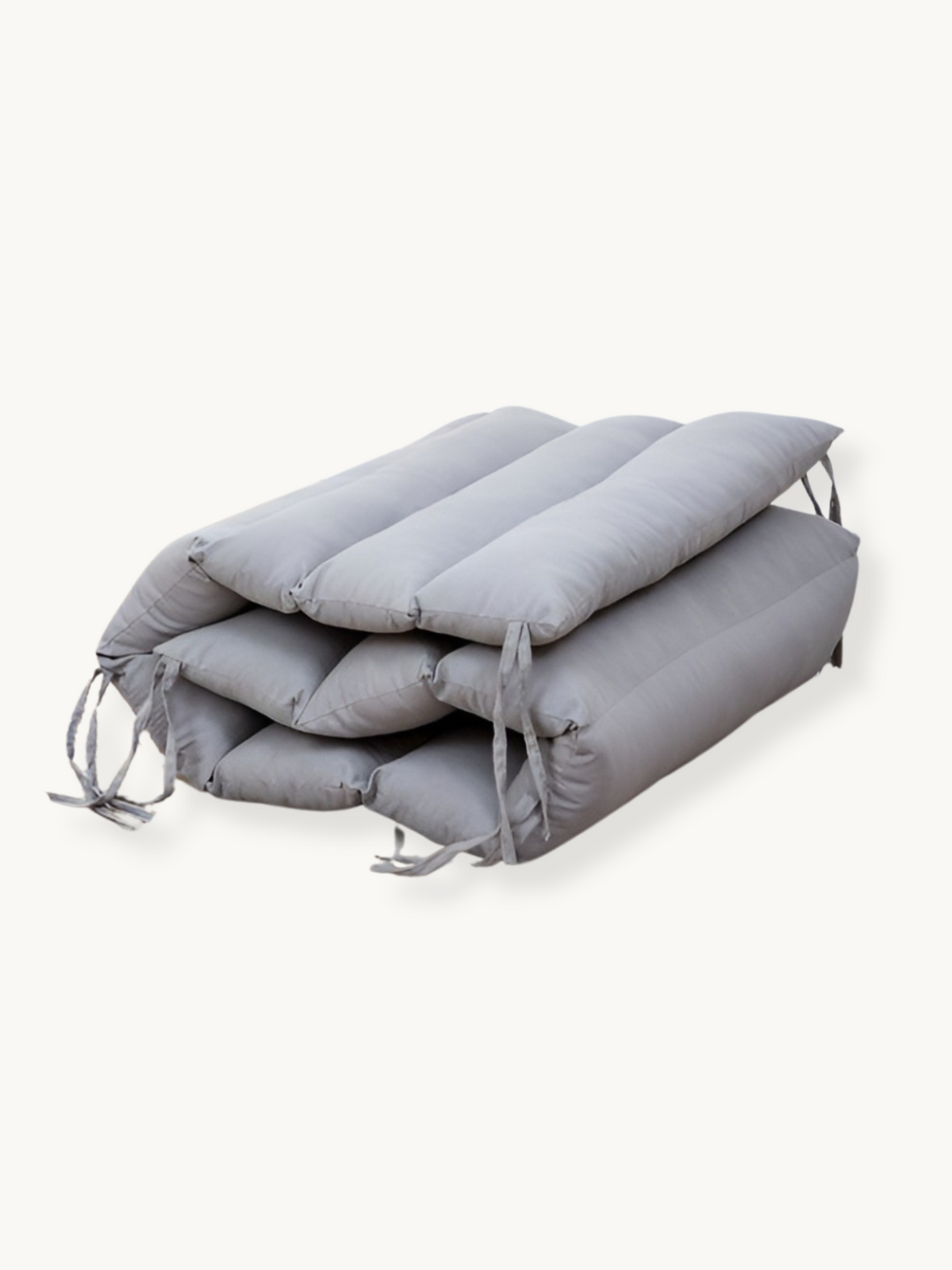 Grey climbing arch cushion folded and stacked in three layers, tie strings visible on sides, angled view on white background