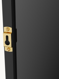 Close-up of gold brass keyhole wall-mount bracket screwed into the slim black aluminium frame edge of the Angelo mirror