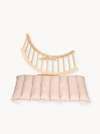 Natural wood XXL climbing arch rocker shown flat with detached blush pink quilted cushion, overhead product view on white…