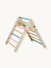 Wooden Pikler triangle climbing frame with pastel blue, pink and yellow rungs, angled product view on white background
