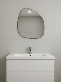 Alaric organic mirror with thin black PVC frame hung above white bathroom vanity and sink, grey tiled wall, lifestyle setting