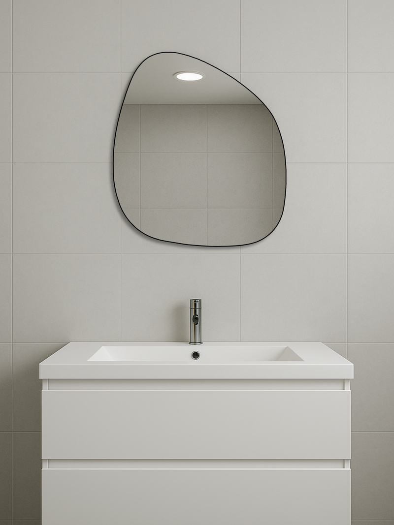 Alaric organic mirror with thin black PVC frame hung above white bathroom vanity and sink, grey tiled wall, lifestyle setting