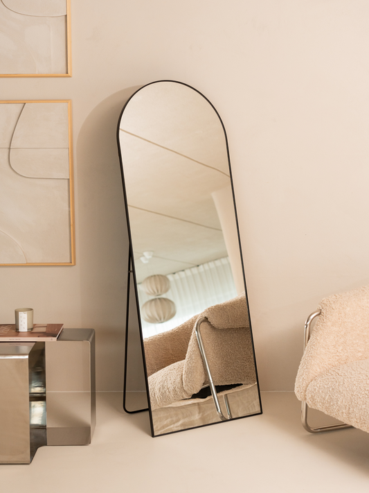 Elegant standing mirror in a stylish room with furniture.