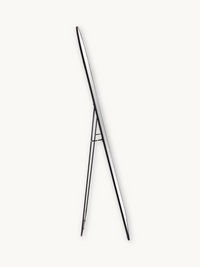 Side profile of black aluminium oval floor mirror on easel stand, showing slim frame depth and A-frame support legs