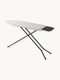 Angled top-down view of taupe ironing board with black steel X-frame legs and dark ribbed iron rest at narrow end