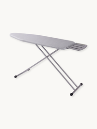 Light grey ironing board angled view showing padded cover, slatted iron rest at narrow end, crossed steel legs, and rubber…